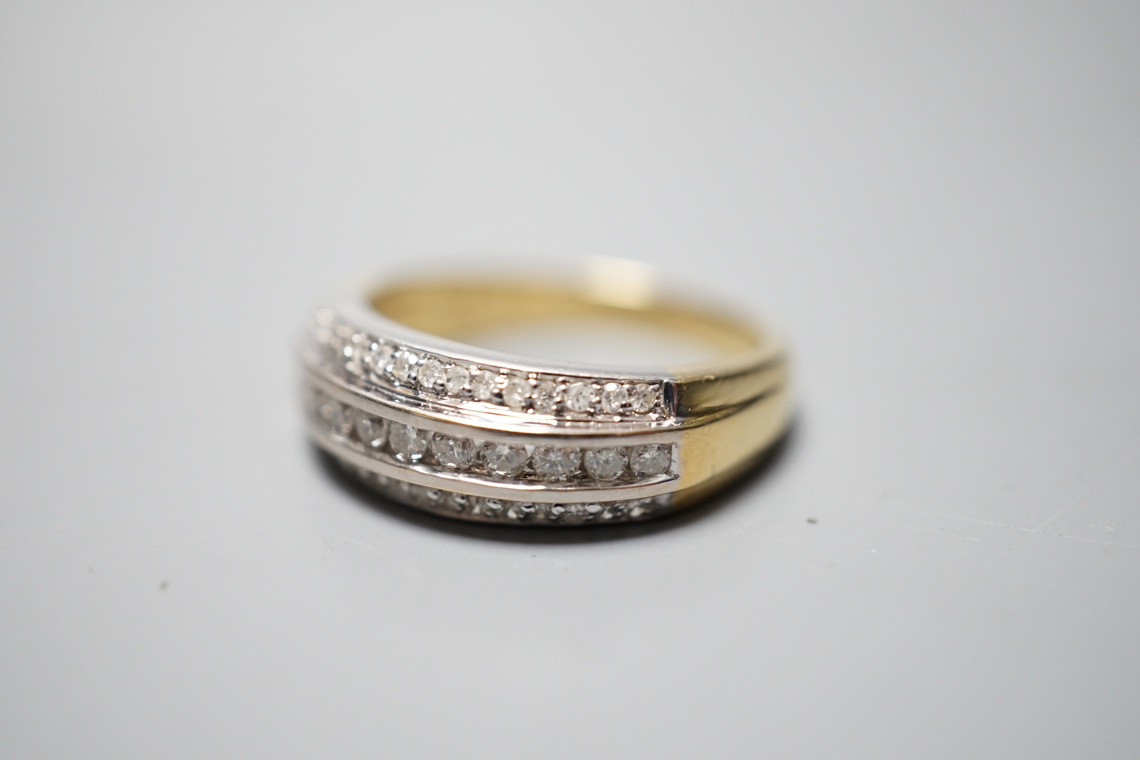 A modern 18ct gold and three row diamond set half eternity ring, size P, gross weight 6.8 grams.